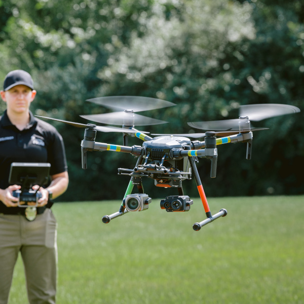 A police officer uses a remote control to fly a drone.