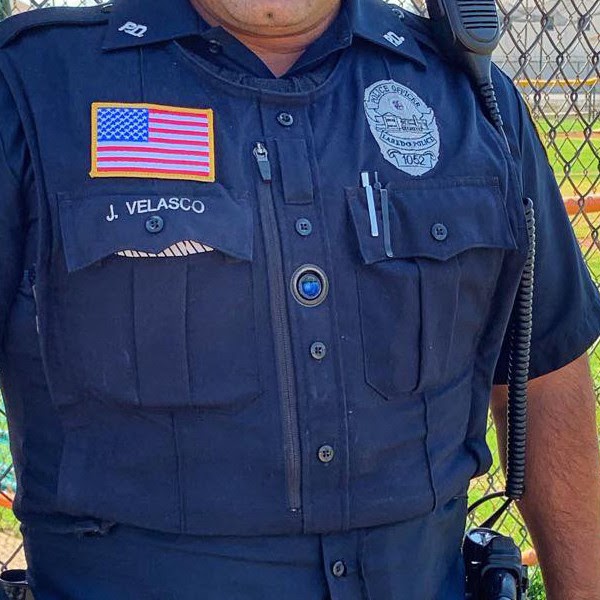 Utility brand body worn camera affixed to an officer's uniform, looking like a button